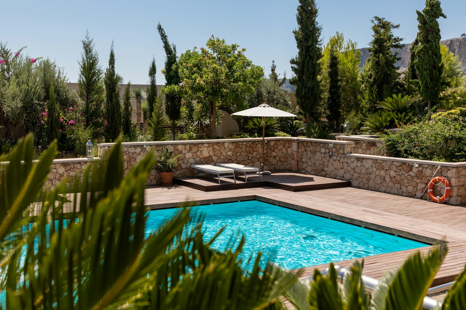 Illustrative outdoor swimming pool surrounded by tropical greenery